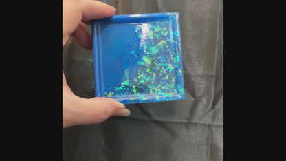 Video of the small handmade square trinket dish in ocean blue showing how the iridescent glitter flakes sparkle and flash in the light.