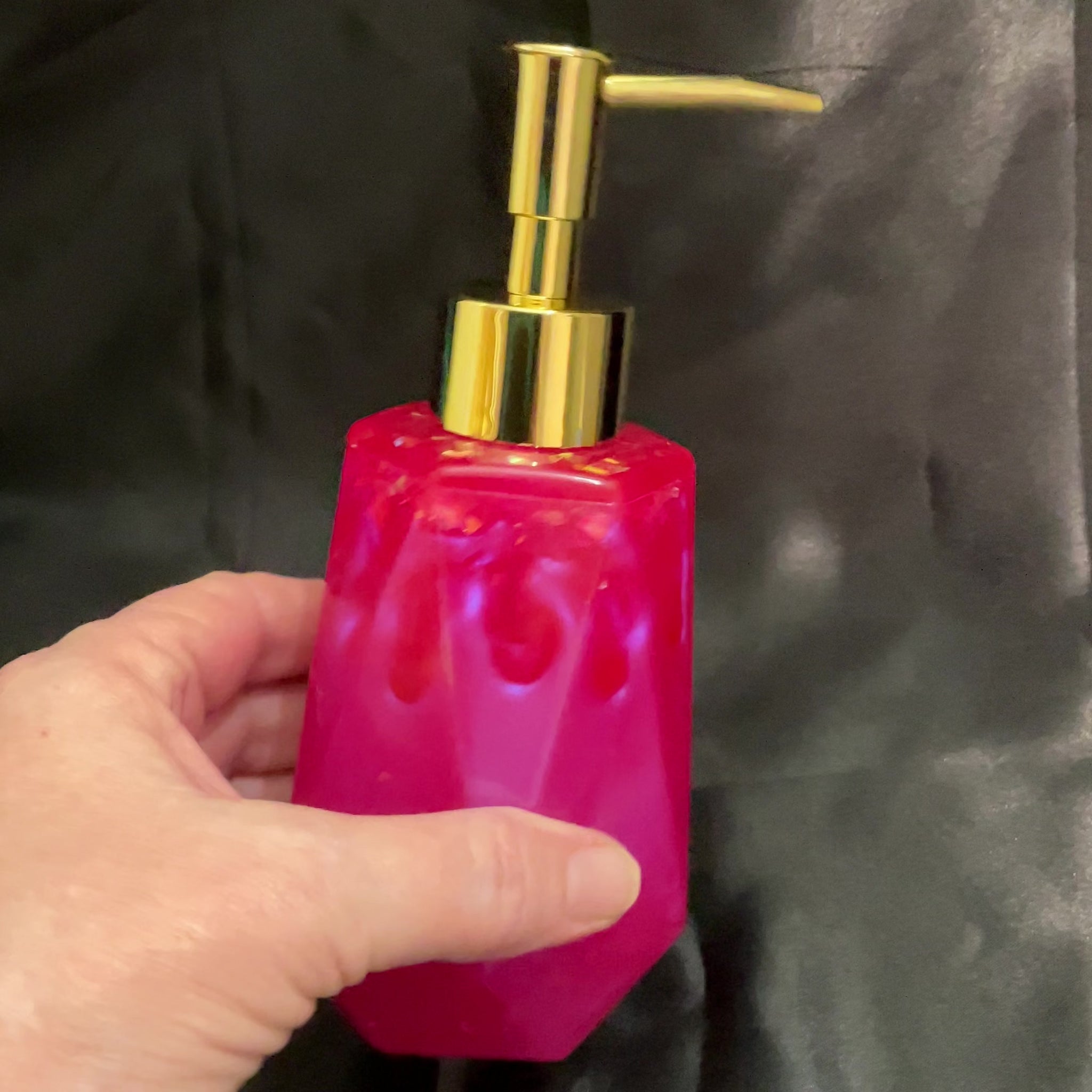 Video of the faceted handmade bright pink resin soap dispenser showing how the iridescent flakes flash color in the light.