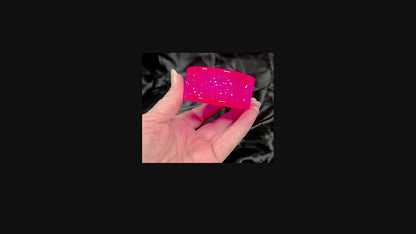 Video of the handmade neon pink resin faux druzy tealight candle holder showing how it sparkles as a hand moves it around in the light.