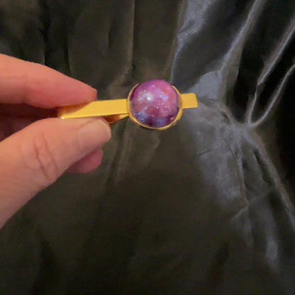 Video of the gold plated color shift tie clip showing how the handmade domed round resin cab shifts from iridescent pink to purple and blue.