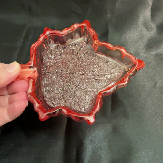 Video of the handmade translucent red and orange resin leaf decorative trinket dish showing how the bottom faceted crystal like area sparkles in the light.