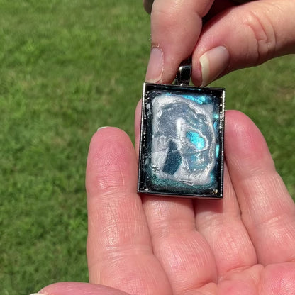 Handmade Abstract Blue Frost Resin Pendant Necklace video showing how the iridescent background shimmers and changes shade in the light.