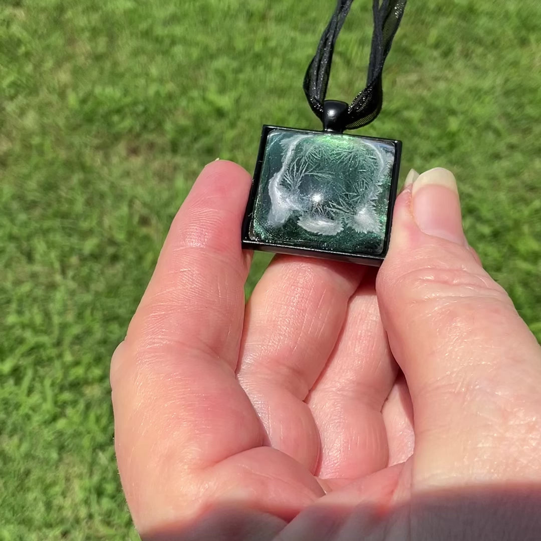 Green and Black Handmade Resin Frost Pendant Necklace video showing how the iridescent green and yellow changes as it moves around in the light.