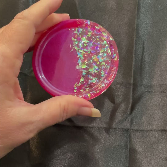 Video of the handmade bright pink resin round small trinket dish showing how the iridescent glitter sparkles in the light.