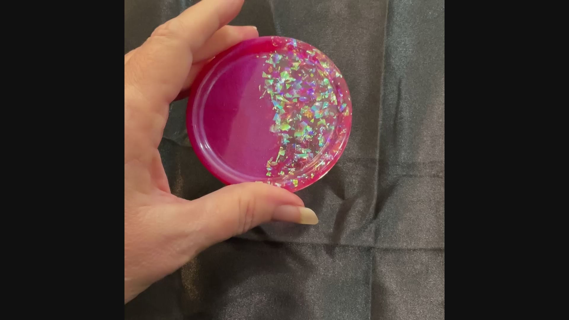 Video of the handmade bright pink resin round small trinket dish showing how the iridescent glitter sparkles in the light.