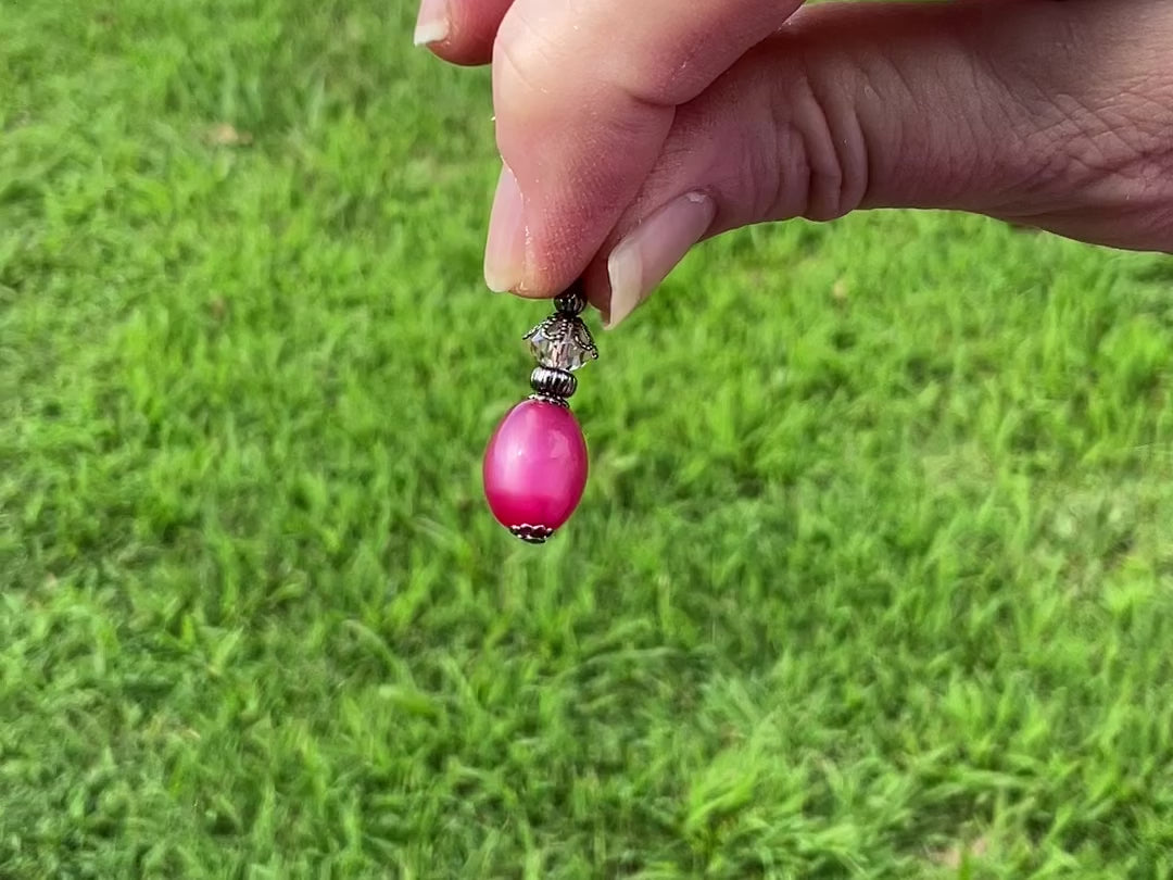 Gunmetal Raspberry Pink Moonglow Lucite Handmade Oval Drop Earrings video showing how the lucite has a glow like effect in the light. 