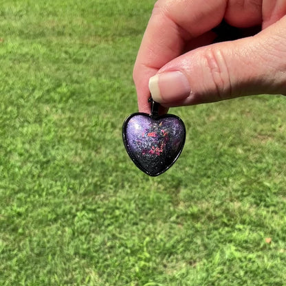 Handmade Purple Resin Black Heart Pendant Necklace with Color Shift Iridescent Glitter video showing how the glitter sparkles and flashes between colors in the light.