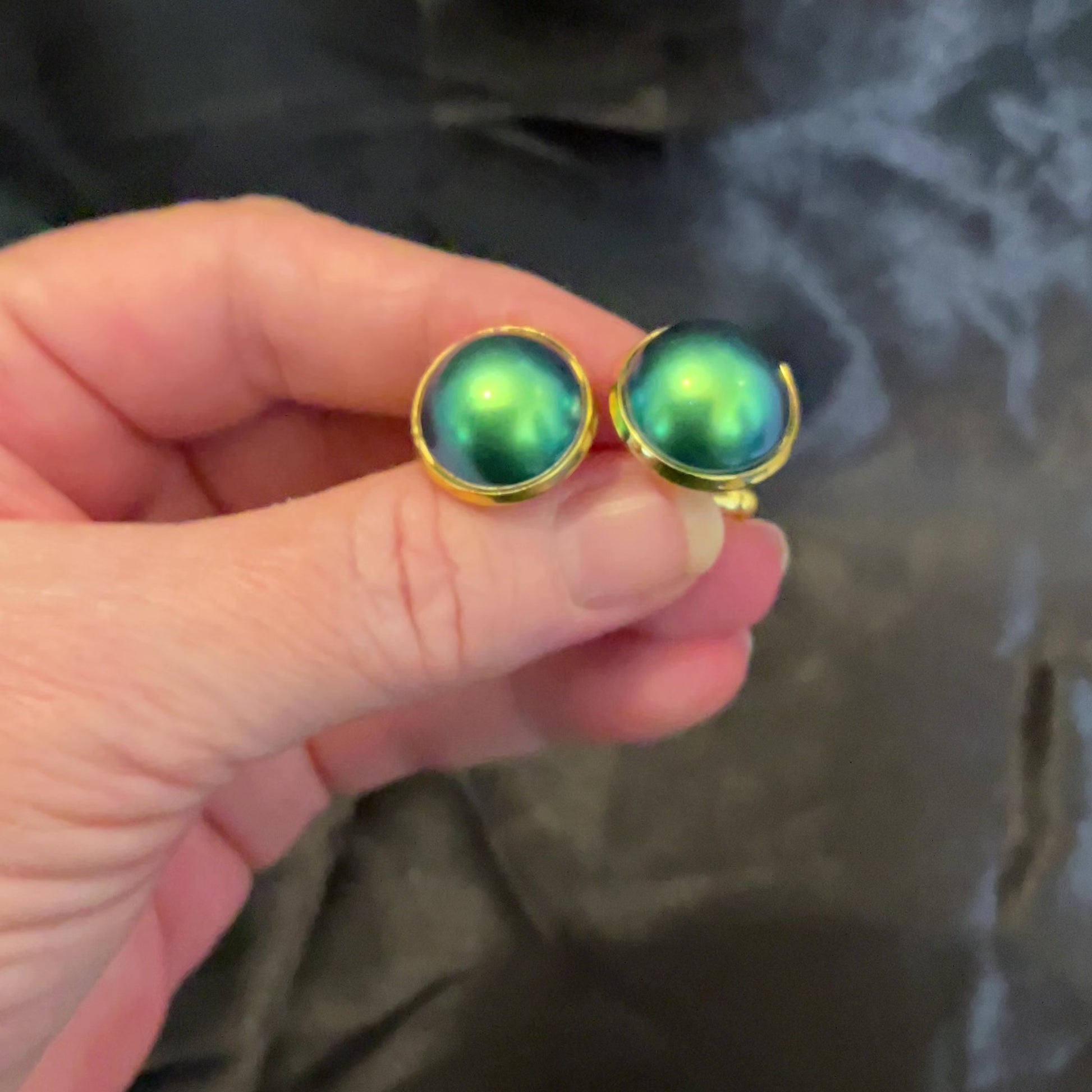 Video of the gold plated color shift cufflinks showing how the resin cabs shift between blue and green depending on how the light hits them.