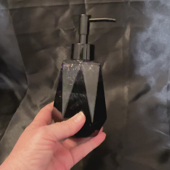 Video of the black glitter soap dispenser showing how there are bands of black resin and glitter resin and how the glitter sparkles in the light.