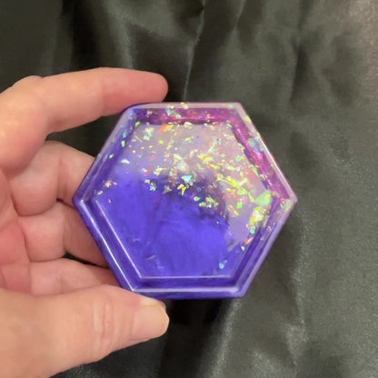 Video of the handmade geometric octagon purple and pink resin trinket dish with iridescent flakes showing how it sparkles and has flashes of color in the light.