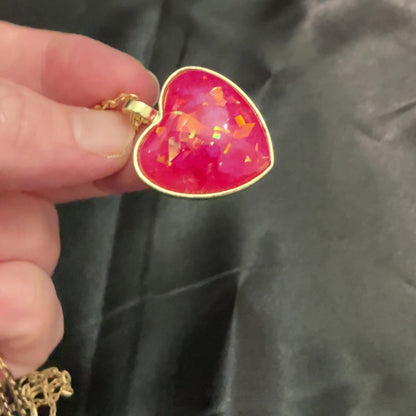 Video of the handmade resin heart pendant showing how the iridescent flakes flash color as the light hits them.