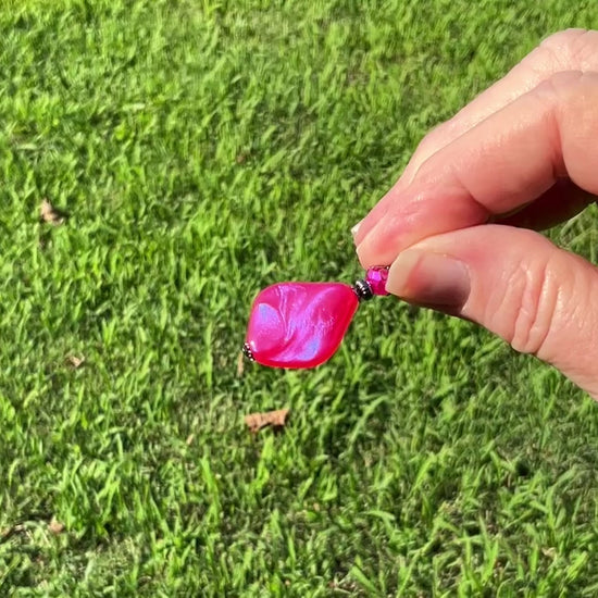 Handmade Color Shift Bright Pink Lucite Earrings video showing how the color shifts to a blue and purple sheen when the light hits it.