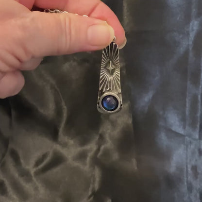 Video of the atomic star pendant necklace showing how the color shift resin cab goes from blue to purple as the light hits it.