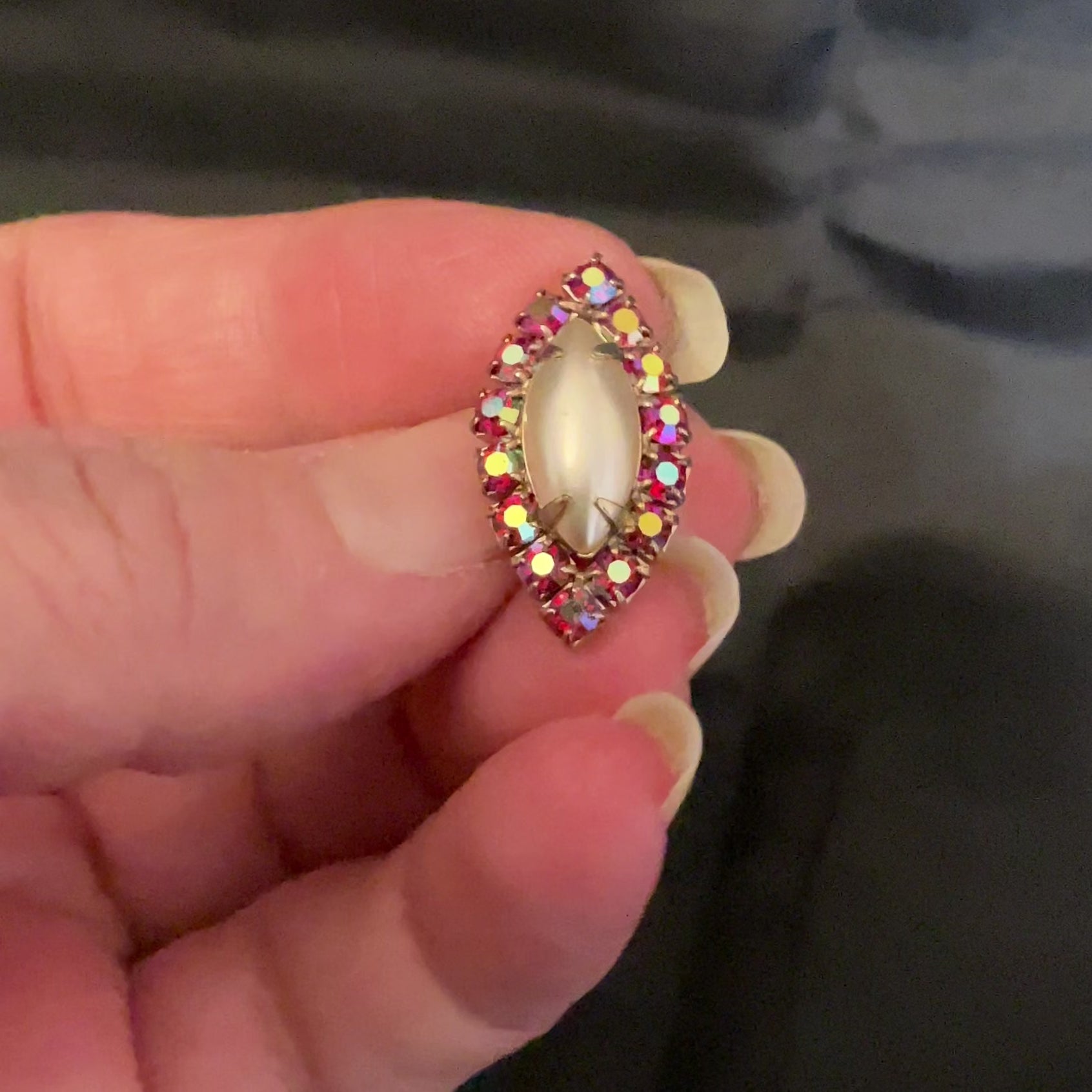 Video of the Mid Century vintage tack pin showing how the AB red rhinestones sparkle in the light.
