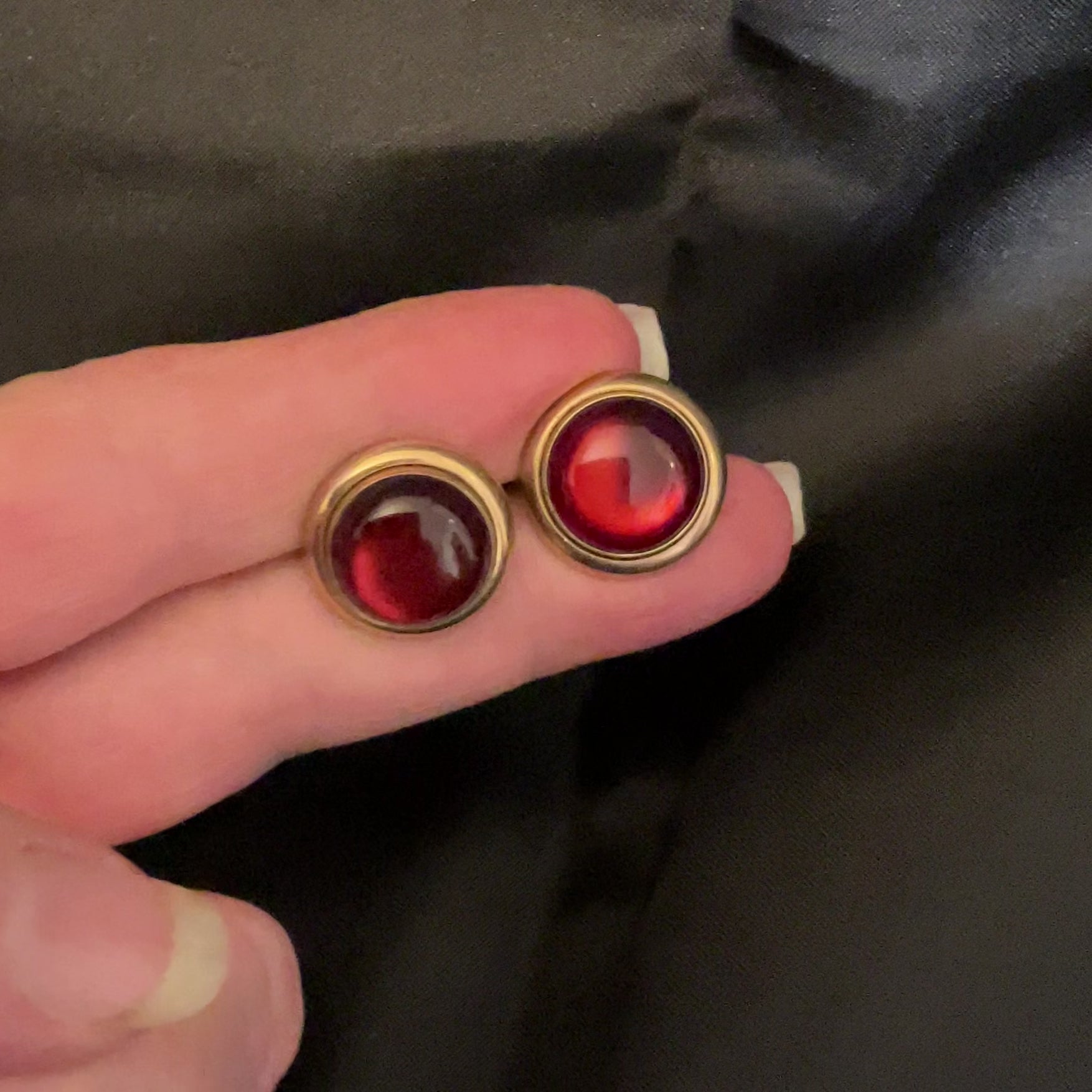 Video of the Mid Century Vintage Swank moonglow lucite cufflinks showing how the maroon red cabs have a glow like effect in the light.