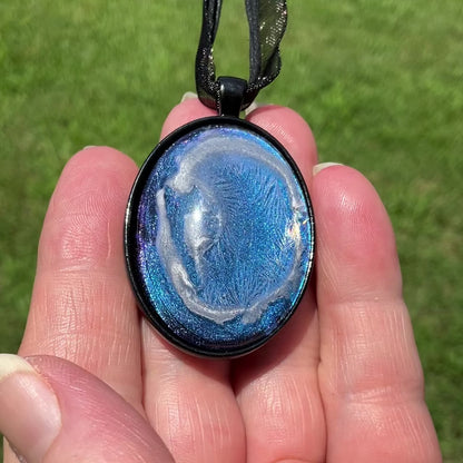 Goth Large Oval Handmade Blue Frost Pendant Necklace video showing how the iridescent background shimmers and changes shade in the light.
