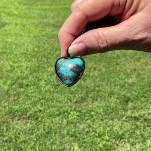 Teal Blue and Dark Gray Handmade Black Heart Resin Pendant Necklace with Holographic Glitter video showing how the glitter sparkles as it moves around in the light.