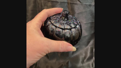 Video of the handmade black resin pumpkin trinket box decorative jar showing how the glitter sparkles in the light.