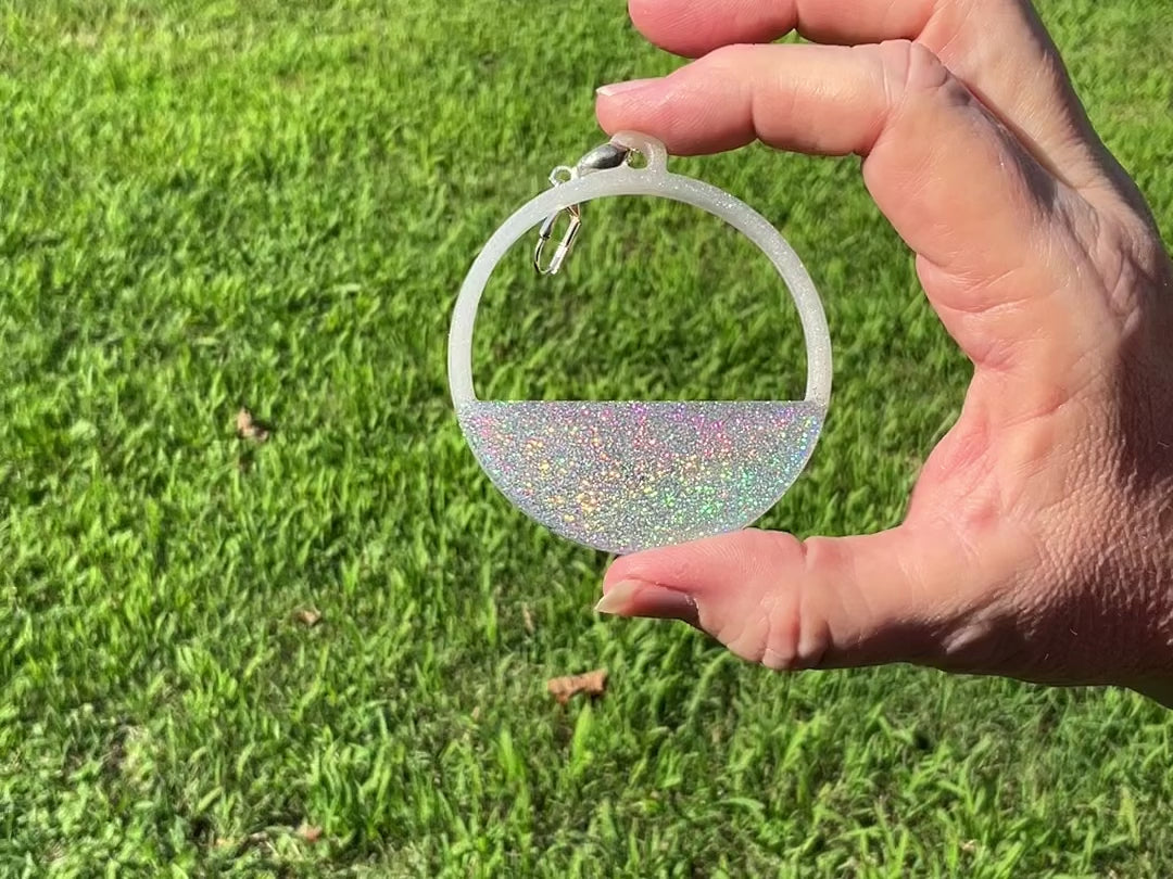 Holographic Glitter Handmade Resin Hoop Earrings video showing how the glitter sparkles and has flashes of rainbow color as it moves around in the light.