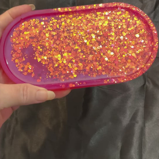 Video of the handmade oval bright pink resin trinket dish tray showing how the iridescent glitter sparkles in the light.