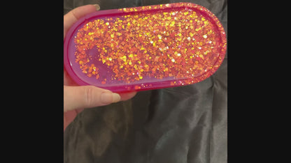 Video of the handmade oval bright pink resin trinket dish tray showing how the iridescent glitter sparkles in the light.