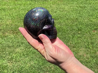 Large Black and Dark Purple Handmade Resin Skull with Holographic Glitter video showing how the glitter sparkles in the sunlight outside.