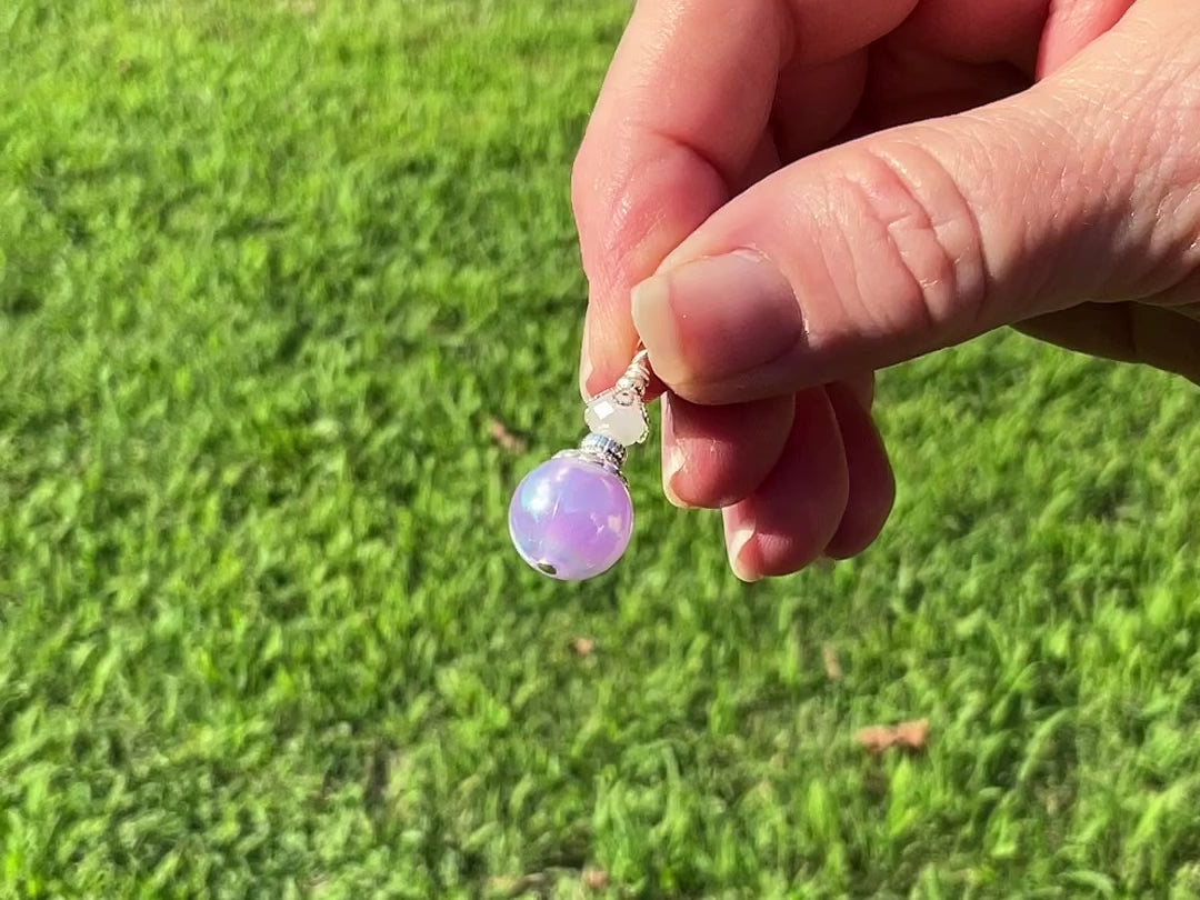 Silver Plated Handmade Pearly Iridescent Purple Drop Earrings video showing how the colors flash as the earrings move around in the light.