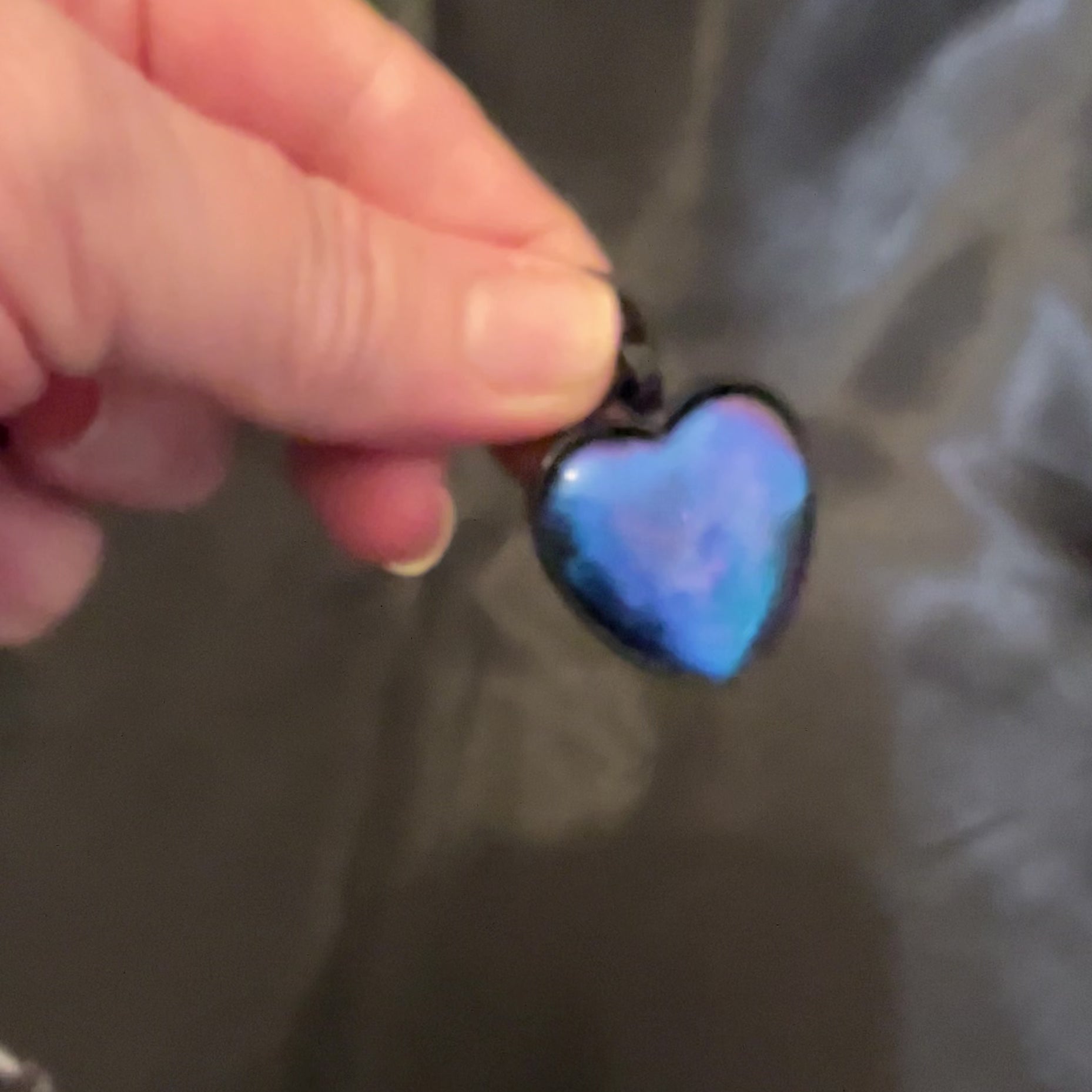 Video of the color shift goth heart pendant necklace showing how the resin goes from blue to purple as the light hits it.