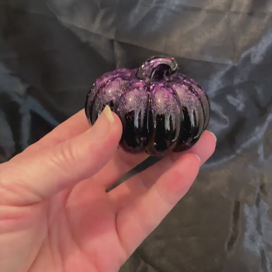 Video of the small shiny black pumpkin with purple glitter showing how the iridescent glitter sparkles in the light.