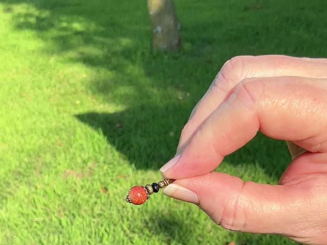 Small Round Handmade Goldstone Drop Earrings video showing how the sparkle in the light.