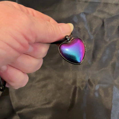 Video of the blue, purple, and pink matte metallic color shift black heart necklace showing how the colors shift as it moves around in the light.