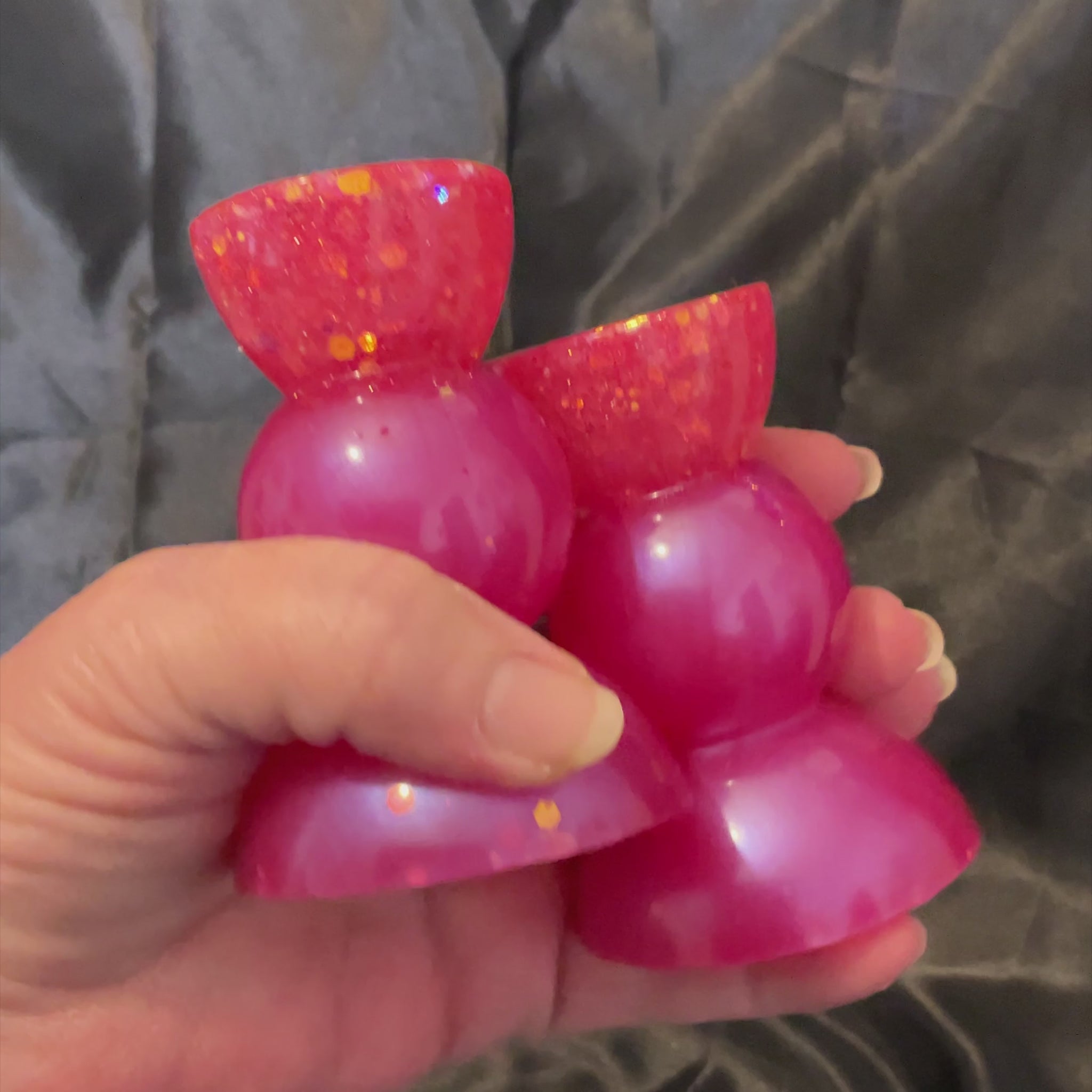 Video showing how the glitter in the handmade bright pink candle holders sparkles in the light.