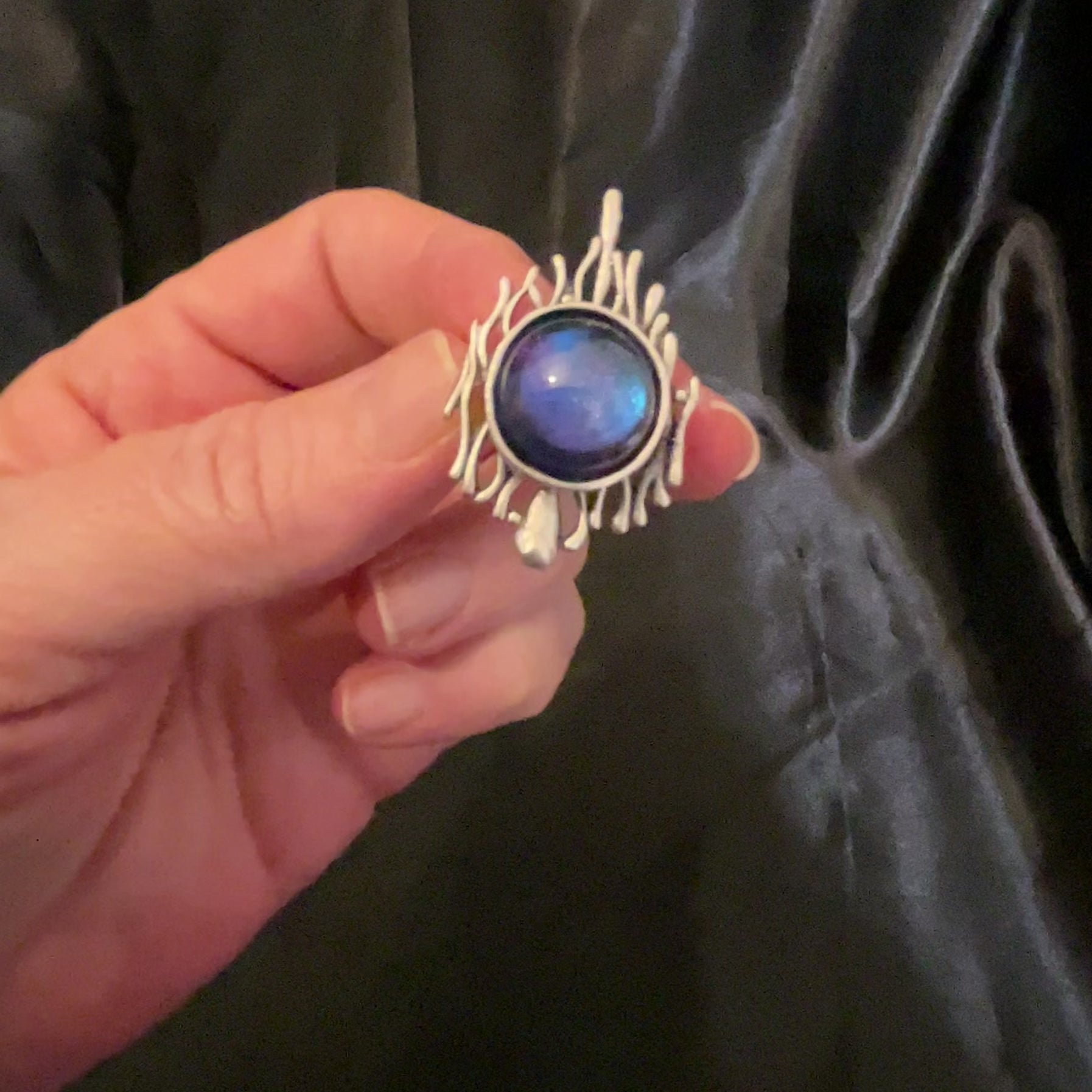 Video of the handmade Brutalist adjustable ring showing how the color shift resin cab goes from blue to purple as the light hits it.