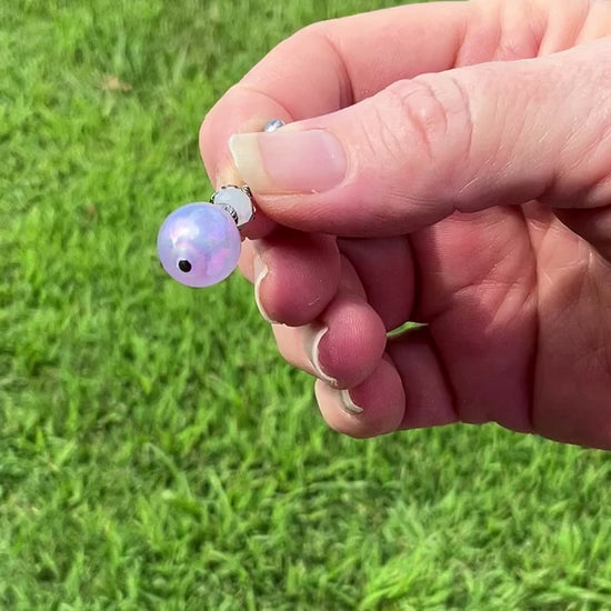 Gunmetal Handmade Iridescent Purple Drop Earrings video showing how the bead has a glow like effect with flashes of color in the light. 