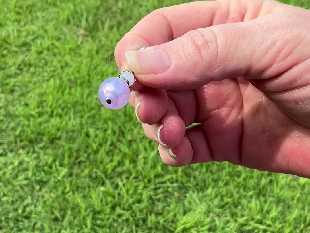 Gunmetal Handmade Iridescent Purple Drop Earrings video showing how the bead has a glow like effect with flashes of color in the light. 