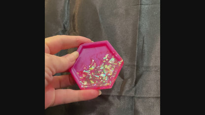 Video of the small handmade bright pink resin geometric hexagon trinket dish showing how iridescent glitter flakes sparkle in the light.