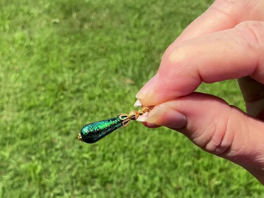 Small Gold Plated Handmade Green Glitter Teardrop Earrings video showing how the glitter sparkles in the light.