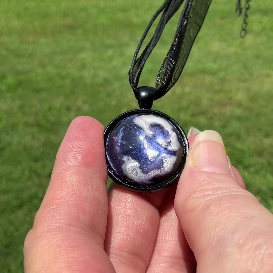 Handmade Black and Iridescent Blue Domed Round Frost Resin Pendant Necklace video showing how the iridescent blue shades shimmer and change in the light.