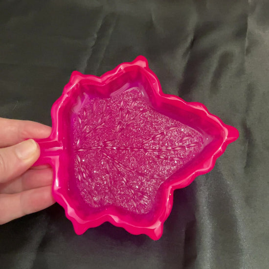 Video of the handmade neon pink resin leaf decorative trinket dish showing how the bottom faceted crystal like area sparkles in the light.