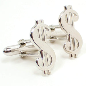 Enlarged angled front view of the Mid Century vintage Swank cufflinks. They are silver tone in color and are shaped like dollar signs. 