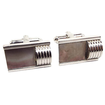Front view of the Mid Century vintage Flex Let Quality cufflinks. They are silver tone in color. The fronts are rectangle in shape with rectangle abalone shell in a gray color. On one side of each cufflink is a corrugated domed shape, giving them a Modernist look.