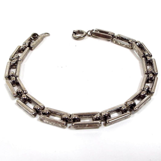 Angled view of the retro vintage link bracelet. It is antiqued silver tone in color and has open rectangle links. There is a spring ring clasp at the end.