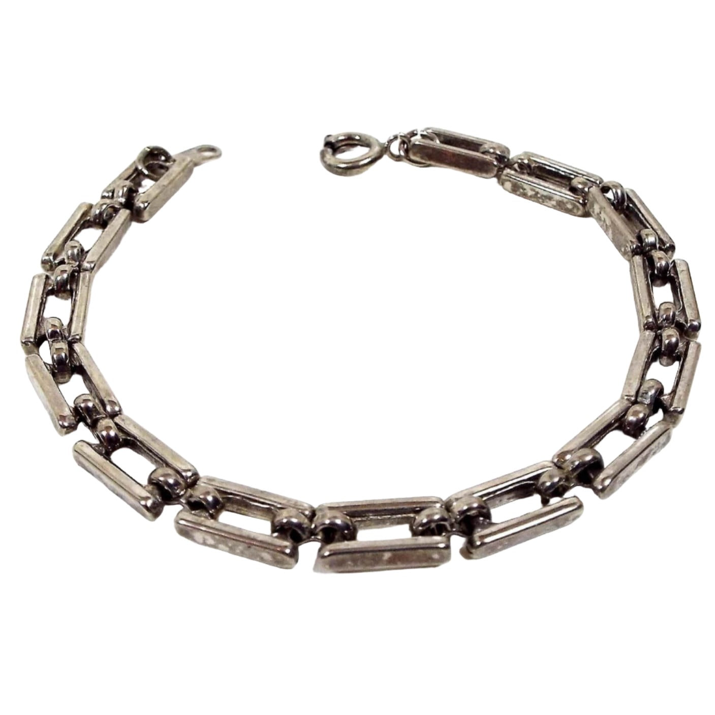 Angled view of the retro vintage link bracelet. It is antiqued silver tone in color and has open rectangle links. There is a spring ring clasp at the end.