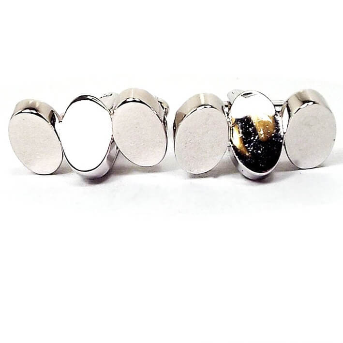 Front view of the retro vintage Hickok geometric cufflinks. They are bright silver tone in color and are shiny. There are three ovals. Two are angled one way and the middle one is angled the other way.