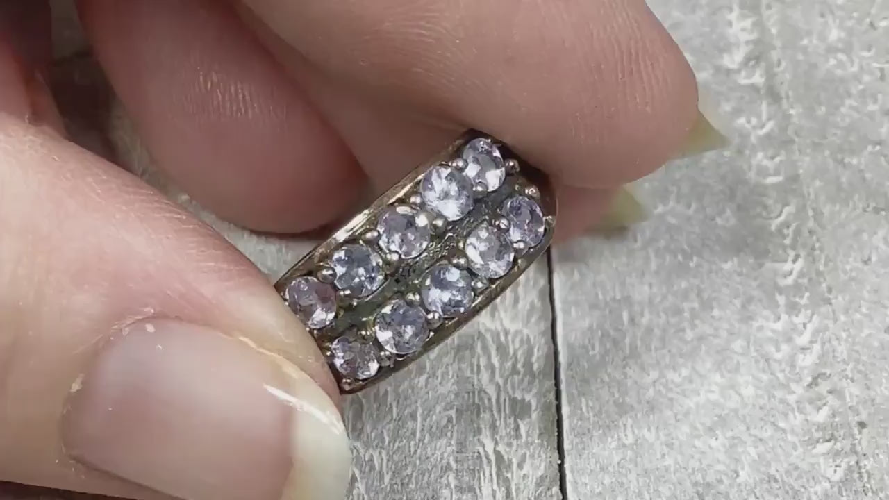 Video of the retro vintage cubic zirconia ring. The metal is sterling silver and there are two rows of CZ stones on the top of the band. The CZ stones are a light purple in color or a light blue depending on the lighting. The video shows them sparkle.