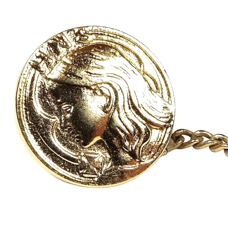 Front view of the 1930's Holy Name Society vintage tie tack. It is gold tone in color and round. It has HNS at the top.