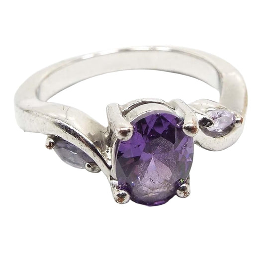 Front view of the retro vintage rhinestone cocktail ring. The metal is silver tone in color. There is a purple oval rhinestone on the top and a marquis clear rhinestone on each side. All stones are prong set.