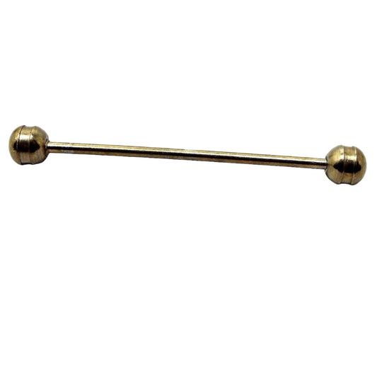 Side view of the Mid Century vintage rounded end collar bar. It is darker gold tone in color and has rounded ends with an indented cut groove on them.