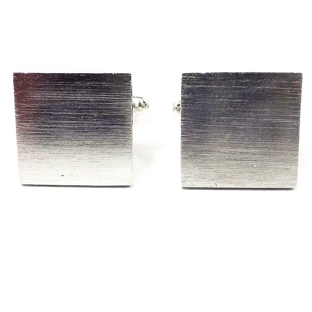 Front view of the retro vintage matte silver tone cufflinks. They are square in shape and have a brushed matte front design.