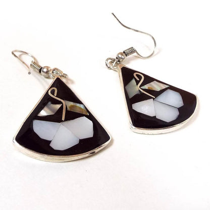 Front view of the retro vintage black enameled floral earrings. The metal is silver tone in color and is a fan drop shape. Earrings have a flower design with mother of pearl petals and abalone leaves. 